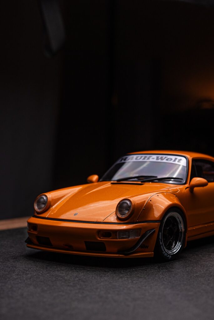 Close-up shot of a vintage orange sports car model with Rauh-Welt decal.